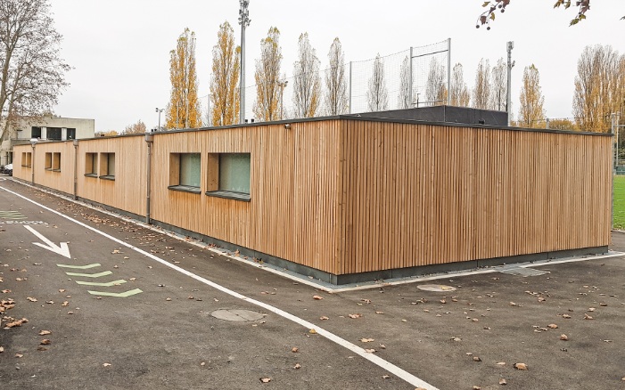 Eingeschossiger Erweiterungsbau mit Holzfassade für die Umkleideräume des Stade des trois Chênes