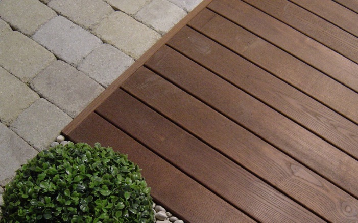 Close-up of a hardwood terrace alongside a green plant and rockery