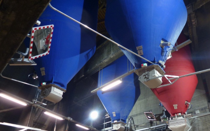 Un silo rond rouge et trois silos ronds bleus intégrés à l’intérieur d’un bâtiment