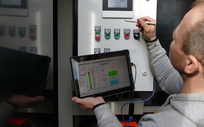 An employee of BL Silobau AG using a tablet to read data from a silo system in the maintenance portal