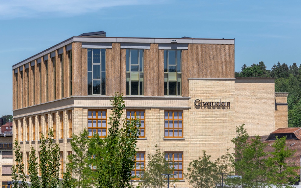 Vue extérieure de l’immeuble de bureaux Givaudan. Grâce à la façade en brique plus sombre, les étages surélevés se distinguent du bâtiment d’origine.