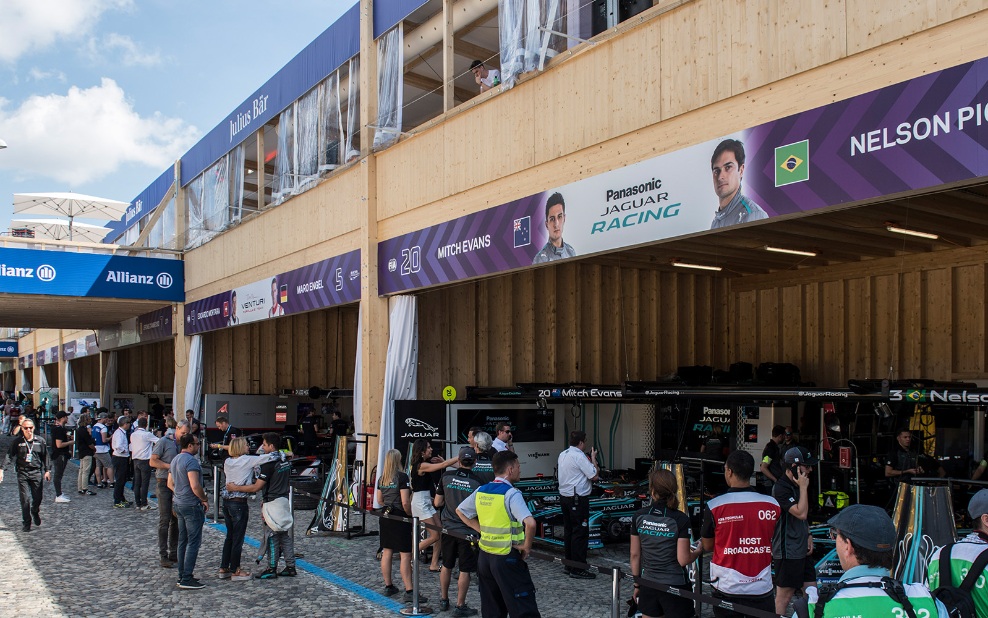 The timber event construction served as a pit lane for the 2018 Zurich E-Prix. Visitors and team members can be seen in the foreground. In the background, the racing cars are in the pits.