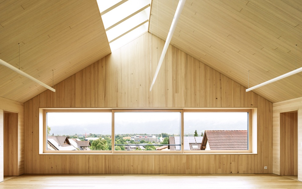 Pièce à haut plafond avec aménagement intérieur en bois et plafond incliné des deux côtés