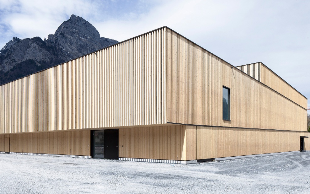 Seitenansicht der Turnhalle Sargans mit Bergmassiv im Hintergrund