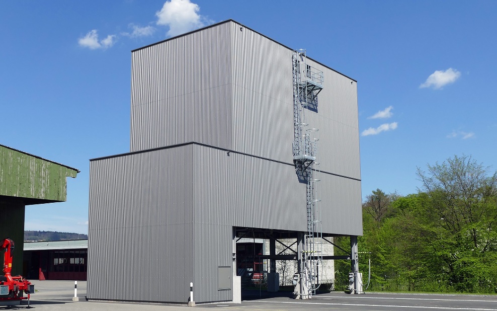 Light grey, architectural 450 m³ modular silo with steel ladder, at a maintenance depot