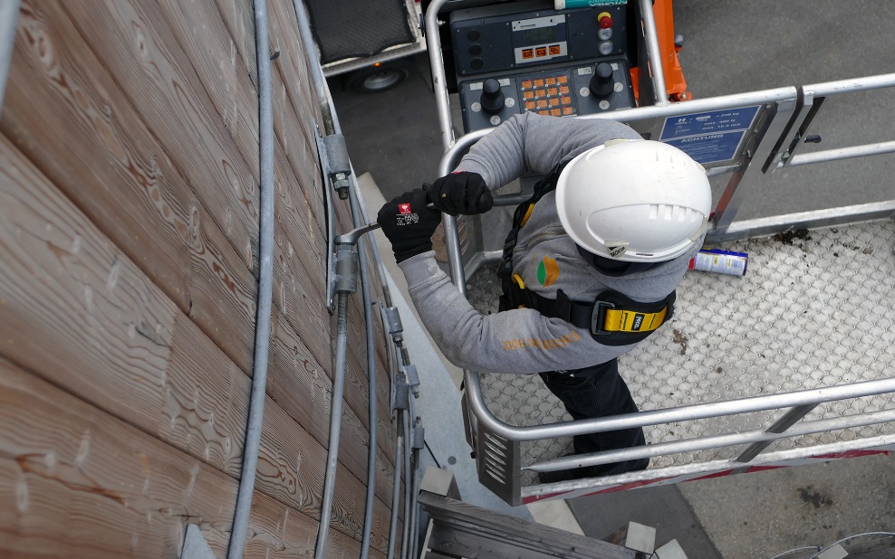 Un collaborateur de BL Silobau AG serre les anneaux en acier sur le silo en bois