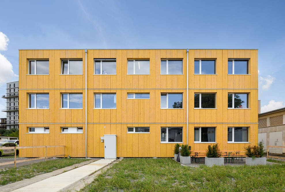 Vue d’ensemble de l’immeuble de bureaux temporaire avec une façade jaune 