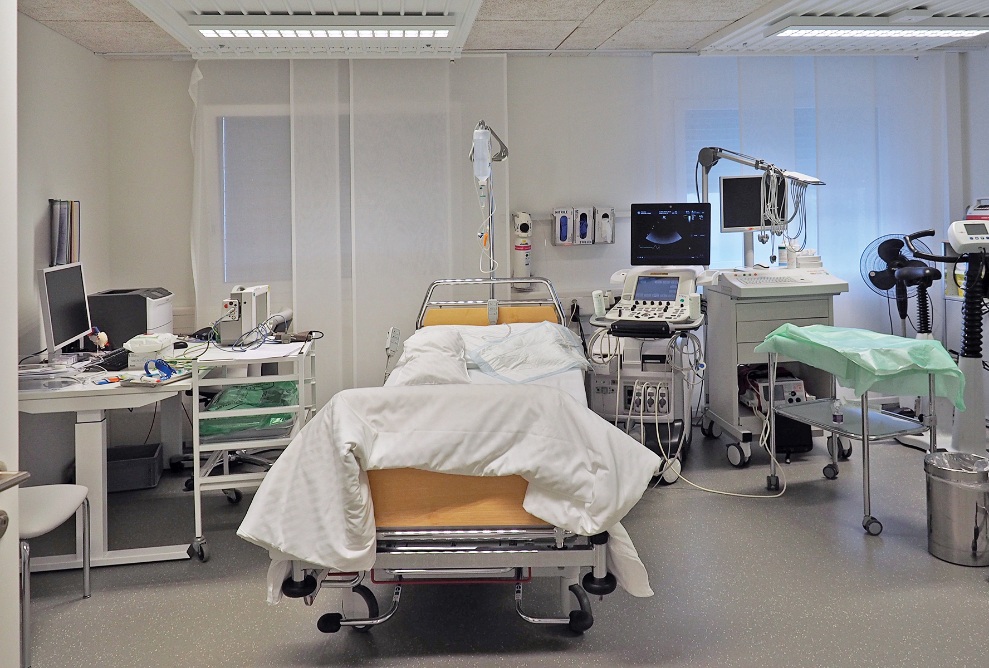 Innenansicht eines Moduls im Spitalprovisorium St.Claraspital. Das Modul ist als Behandlungszimmer eingerichtet mit Pflegebett, Ultraschallgerät, Schreibtisch und verschiedenen anderen Medizinalgeräten.