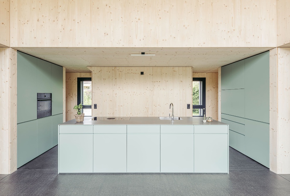 Interior view of the detached house, with the kitchen and dining area defined by the striking appearance of the three-ply spruce cladding on the walls and ceiling. 