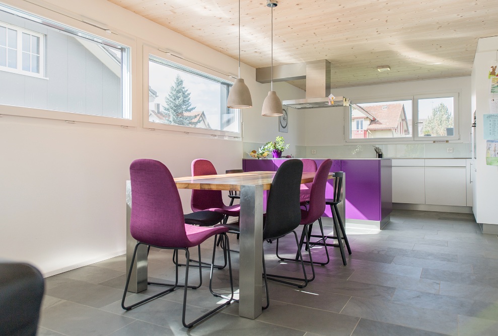 Vue intérieure de l’annexe de la maison individuelle; salle à manger lumineuse avec table et chaises.