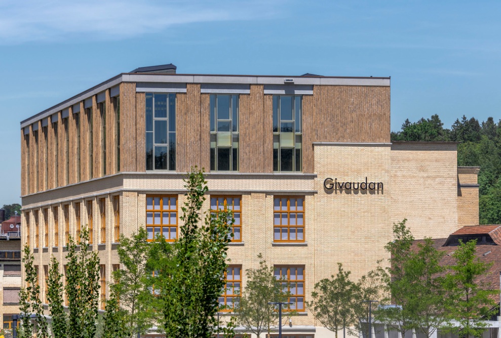 Vue extérieure de l’immeuble de bureaux Givaudan. Grâce à la façade en brique plus sombre, les étages surélevés se distinguent du bâtiment d’origine.