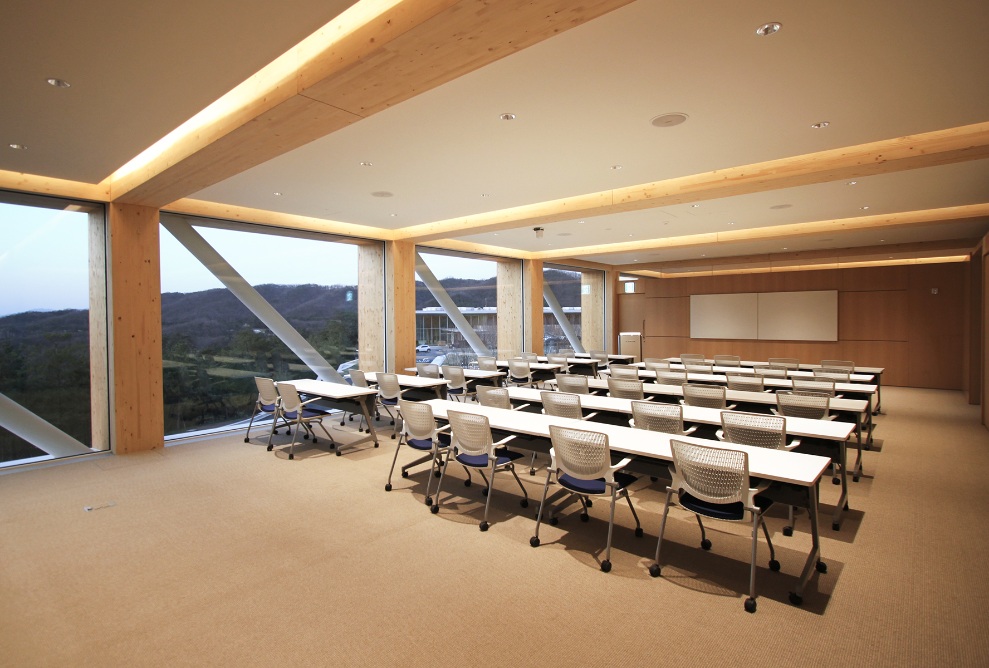 Club de golf Haesley Nine Bridges, vue intérieure d’une salle de classe du Learning Centre au crépuscule, avec lumière artificielle