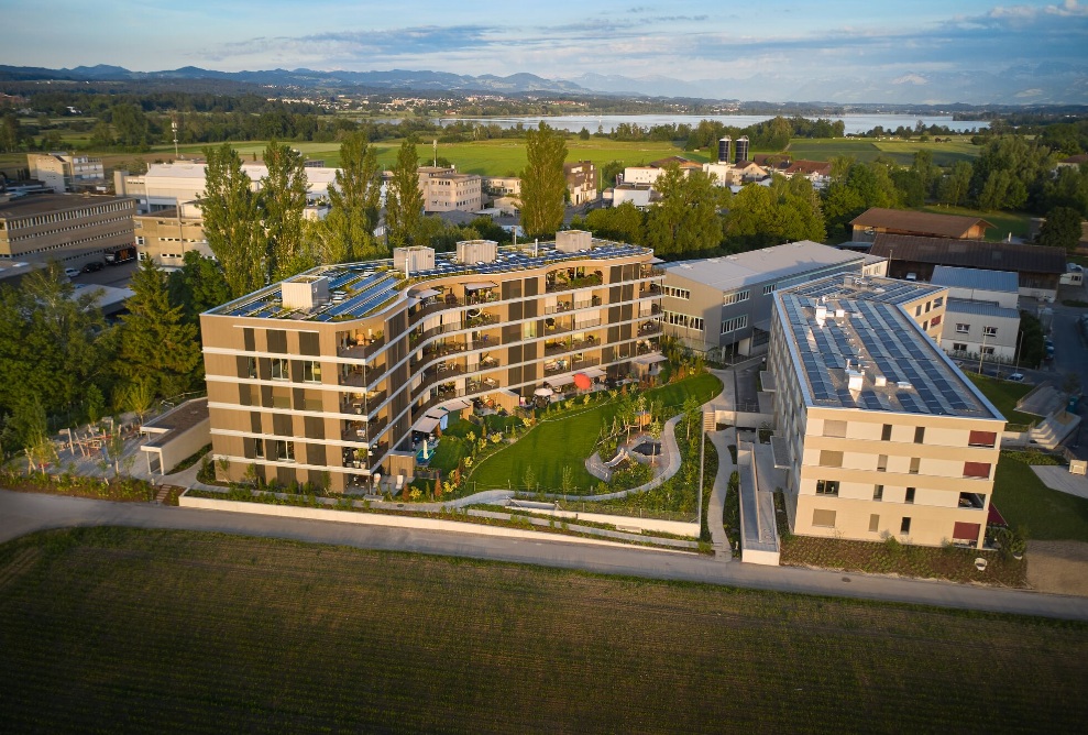 Superstructure du Sunnehof ; vue générale depuis le côté. L'apparence de ce complexe résidentiel respectueux de l'environnement est déterminée par la façade pré-grise en construction classique à ossature bois. 