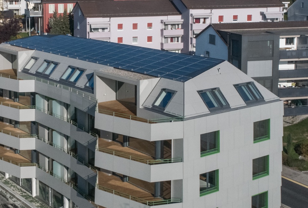 Luftaufnahme des Mehrfamilienhauses Berg mit Sicht auf die mit Holz belegten Terrassenböden der einzelnen Wohnungen