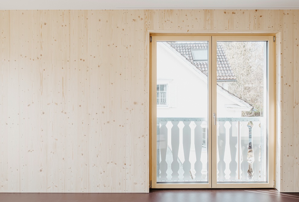 Salon avec mur en bois et portes de balcon