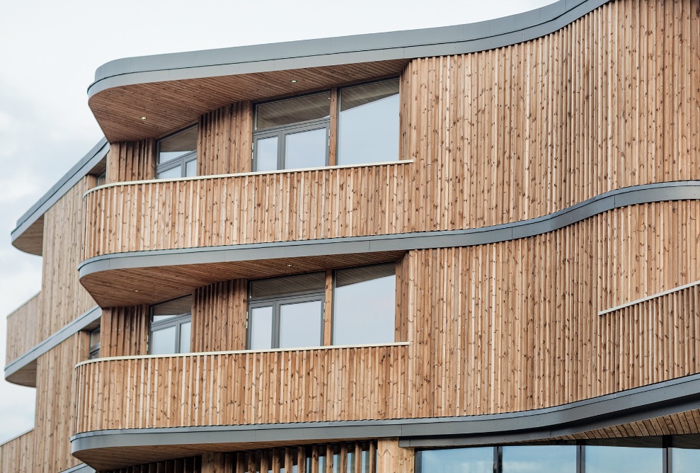 Close-up of the Samling library building with its distinctive timber facade and curved balconies.