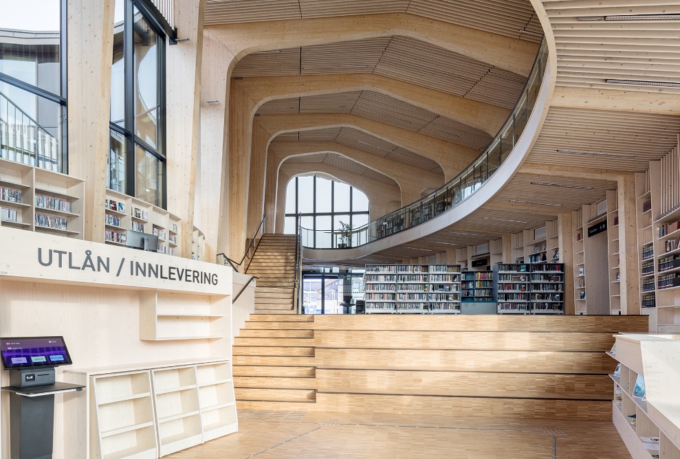 Bibliothek mit Galerie und Bücherregalen in geschwungener Bauform aus Holz.