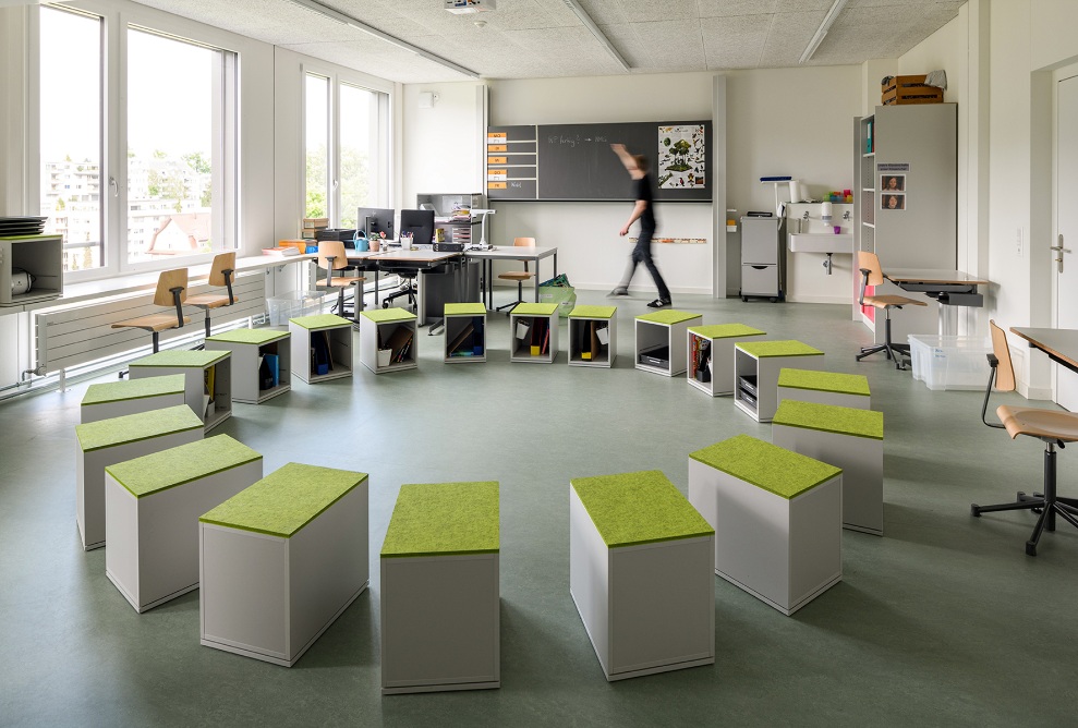 Innenansicht eines Klassenzimmers im Schulhaus Grenzhof in Luzern, mit kreisförmig angeordneten Sitzwürfeln