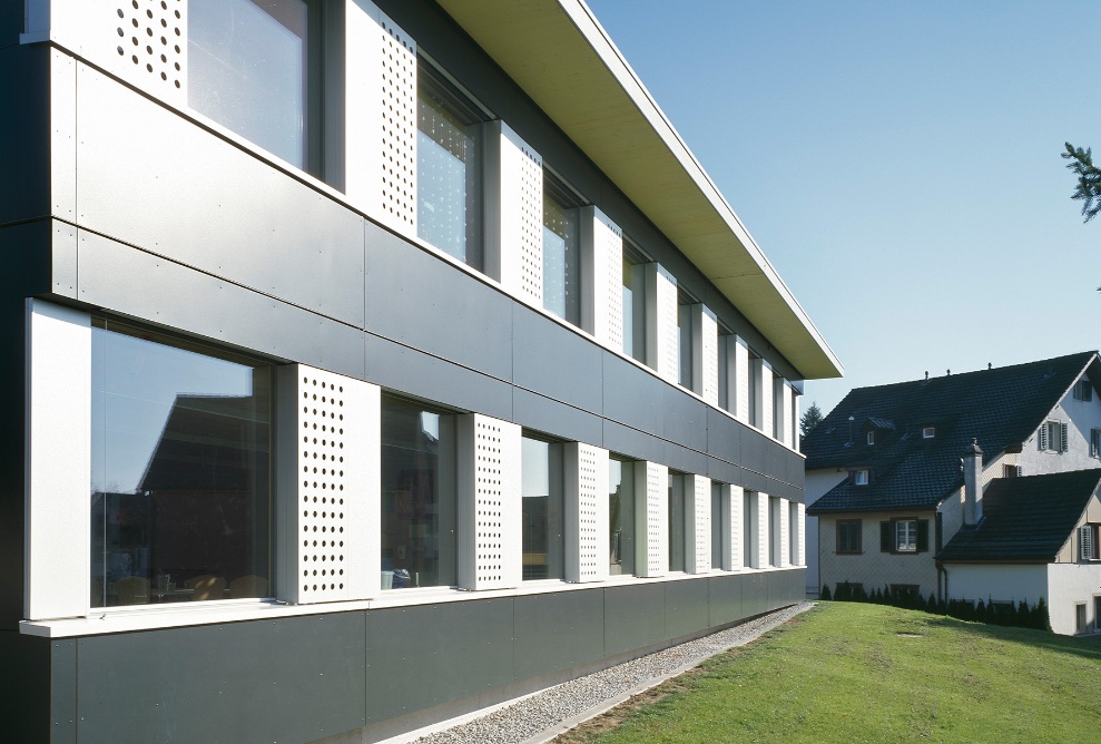 Nahaufnahme der anthrazit weissen Fassade des Schulpavillons Hasenacker in Männedorf. 