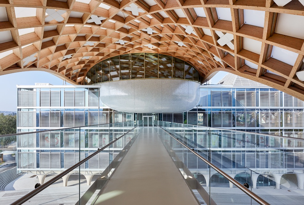 Vue depuis la passerelle sur le bâtiment du musée de la Cité du Temps. L’ossature grillagée en bois forme la couverture