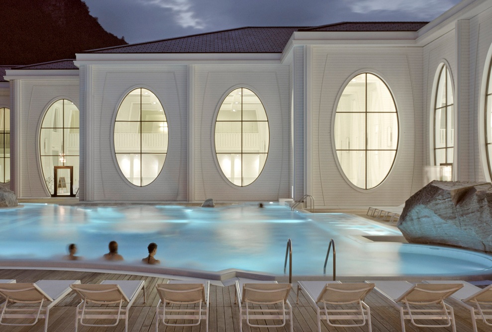 Vue extérieure des Thermes Tamina la nuit avec piscine extérieure éclairée