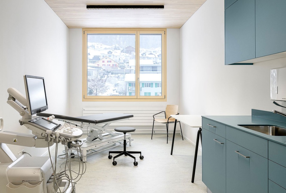 Salle de soins lumineuse dans un module en bois.