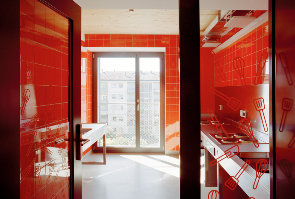 Blick in die Küche mit roter Wandverkleidung
