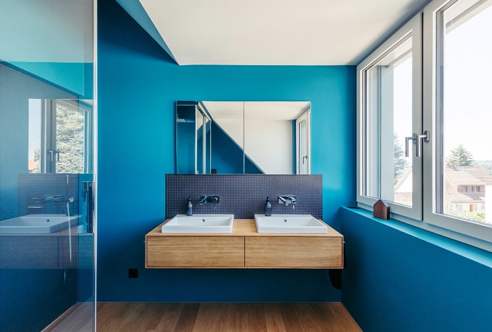 Badezimmer mit blauen Wänden, grosser Fensterfront und Doppellavabo