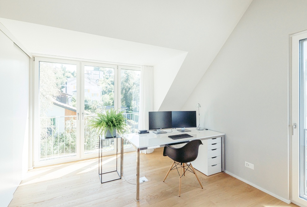 Bright study in the top floor extension with a sloped ceiling and wooden floor