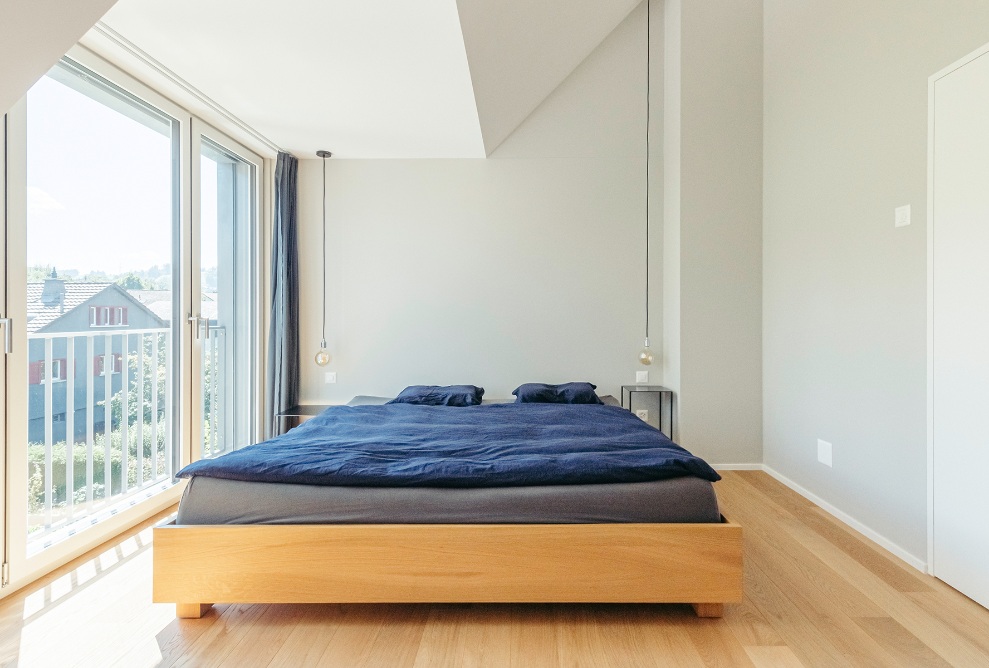 Couloir avec plancher en bois et fenêtre de toit dans la mansarde inclinée