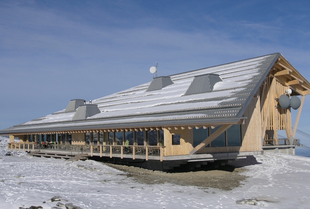 Aussenansicht Berggasthaus Chäserrugg mit Schnee auf dem Dach und schneebedecktem Boden. 