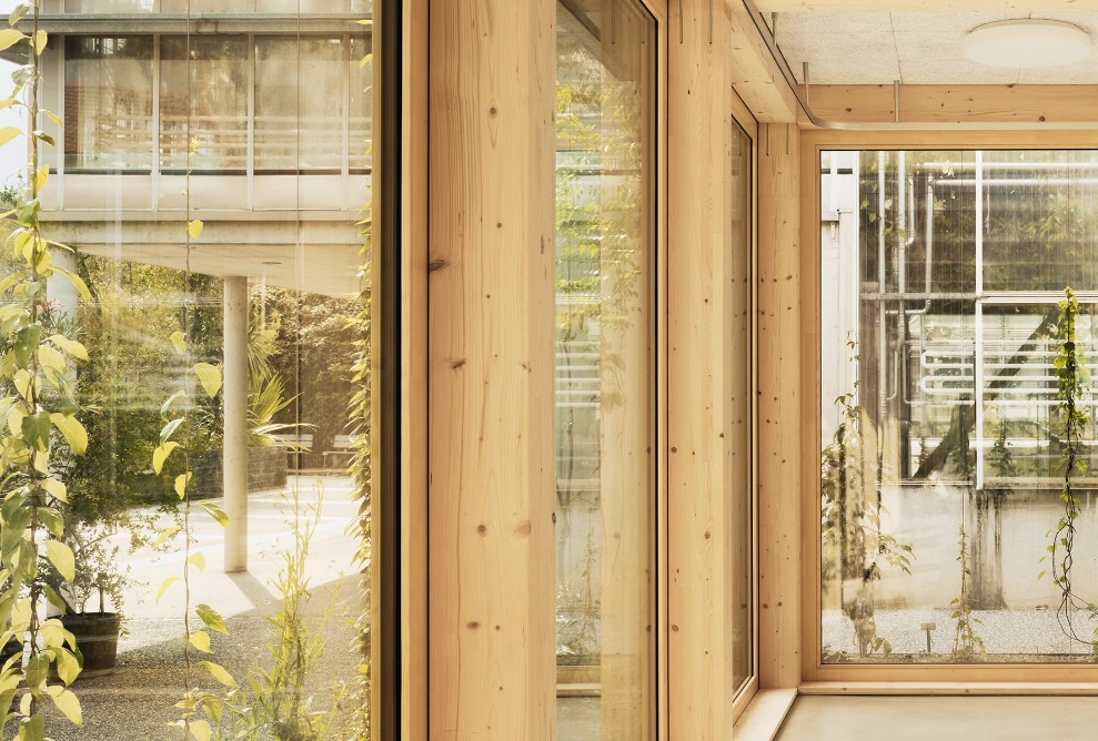 View through the wood and glass walls of the newly built lecture room in the botanical garden in St. Gallen