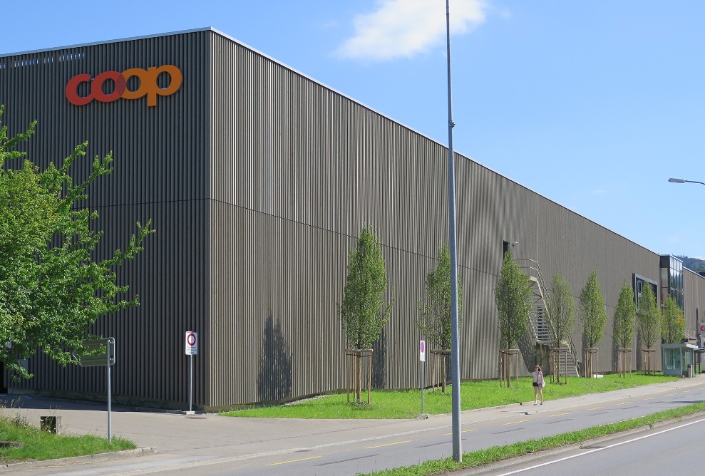 Côté long du Coop Super Center Uzwil rénové, avec sa façade en bois prégrisé.