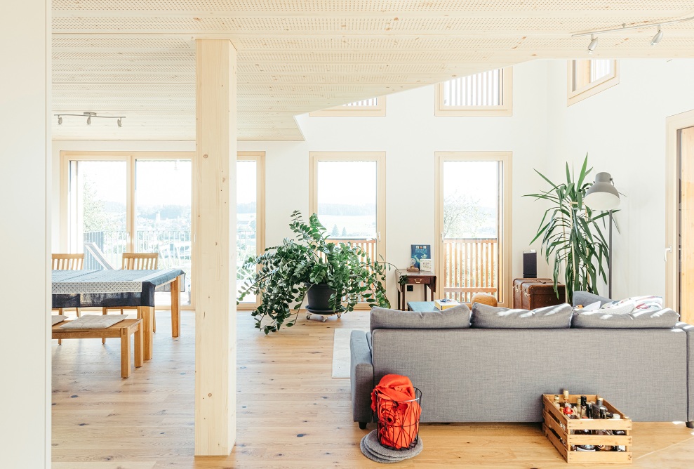 Offener Wohn- und Essbereich des Einfamilienhauses mit Holzsäule und Lignaturdecke.