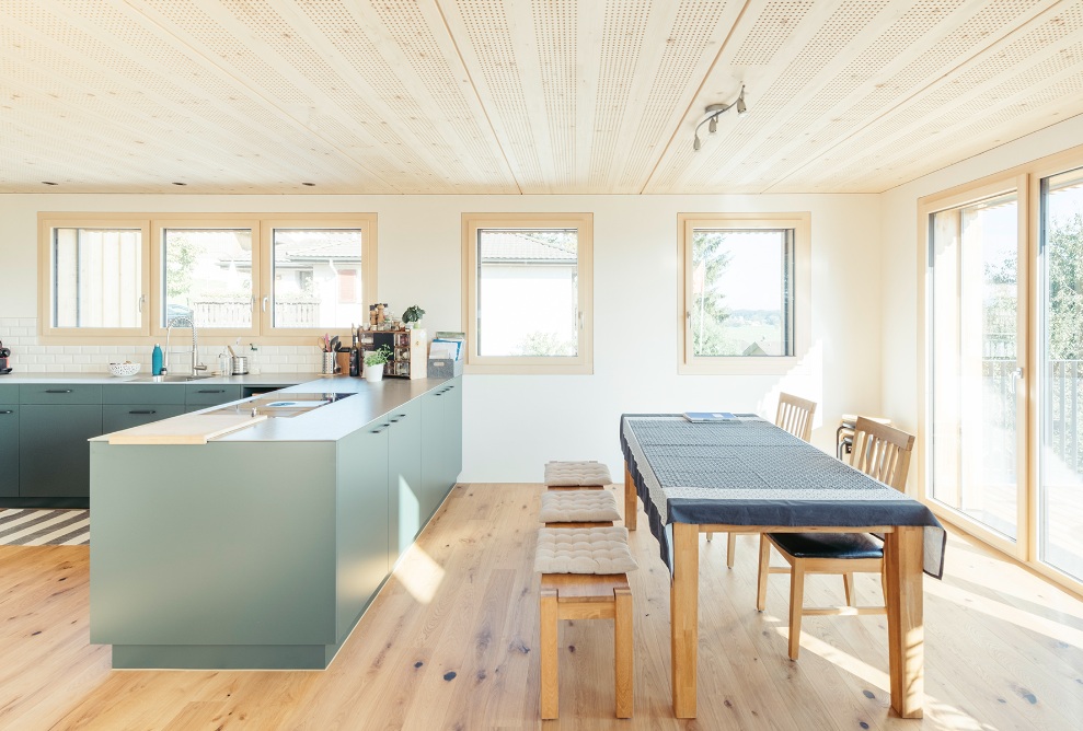 Espace salle à manger ouvert et lumineux et cuisine moderne avec beaucoup de bois