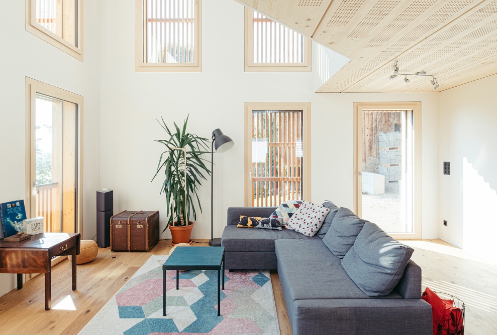 igh-ceilinged living room with plenty of windows as well as a wooden ceiling and floor