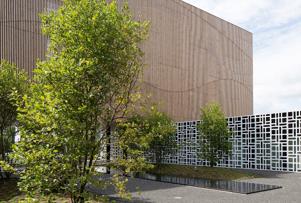 The photograph shows the green spaces and gravel area decorated with a water basin to the rear of the Hotel Säntispark. A covered lounge can also be seen.