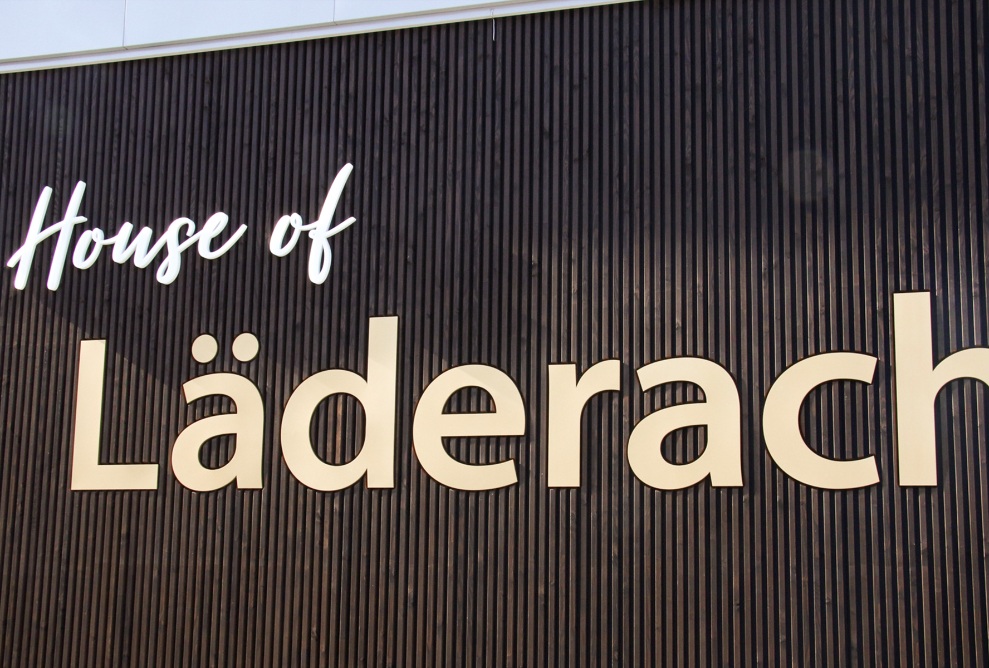 Dunkle Holzfassade mit Läderach-Logo und Schriftzug