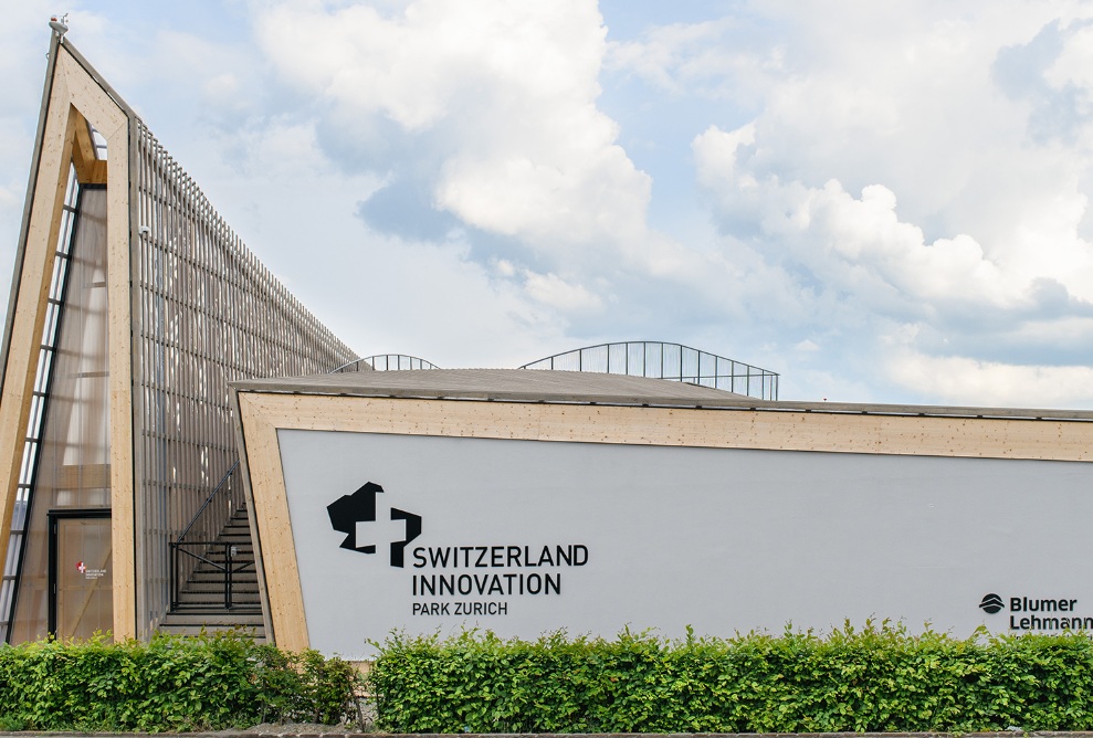 Blick auf den fertigen Bau des Switzerland Innovations Parks mit grüner Hecke. 