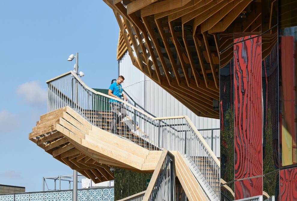 Aus mehreren Abschnitten bestehende Holztreppe an der Pavillonfassade