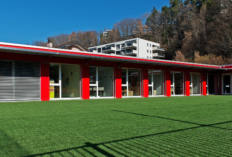 Aussenansicht vom Modulbau Kindergarten mit Garten bei schönem Wetter