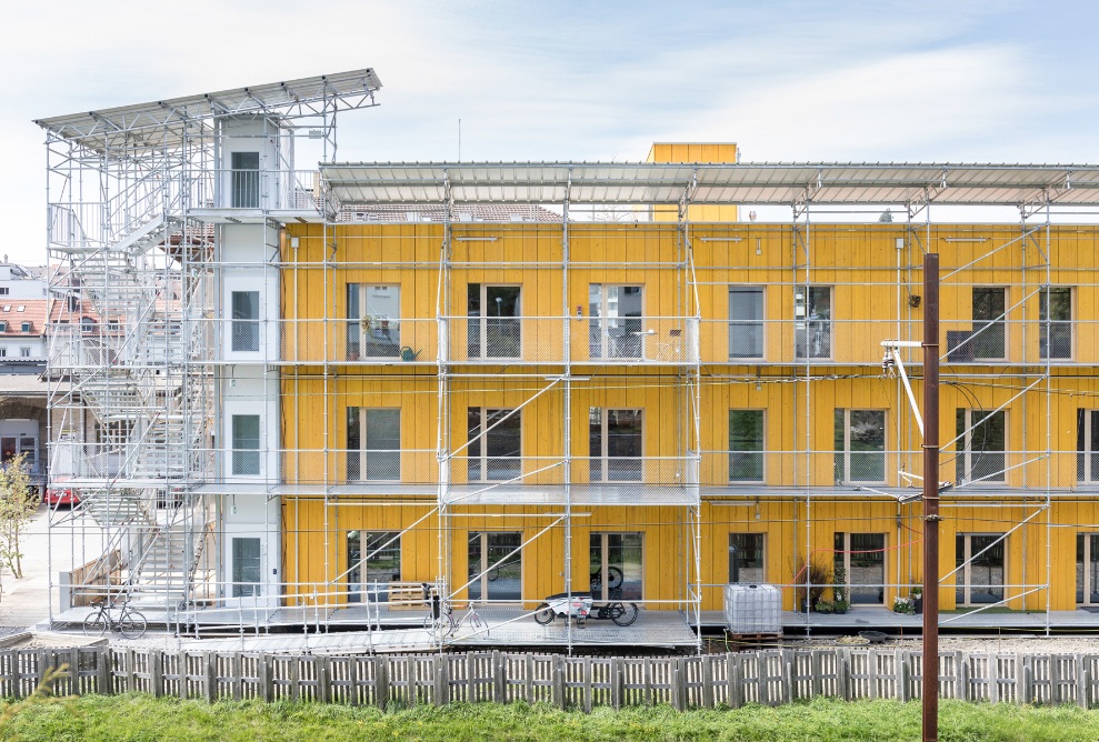 Fassadenansicht der Überbauung Lattich mt Baurüstung bei schönem Wetter