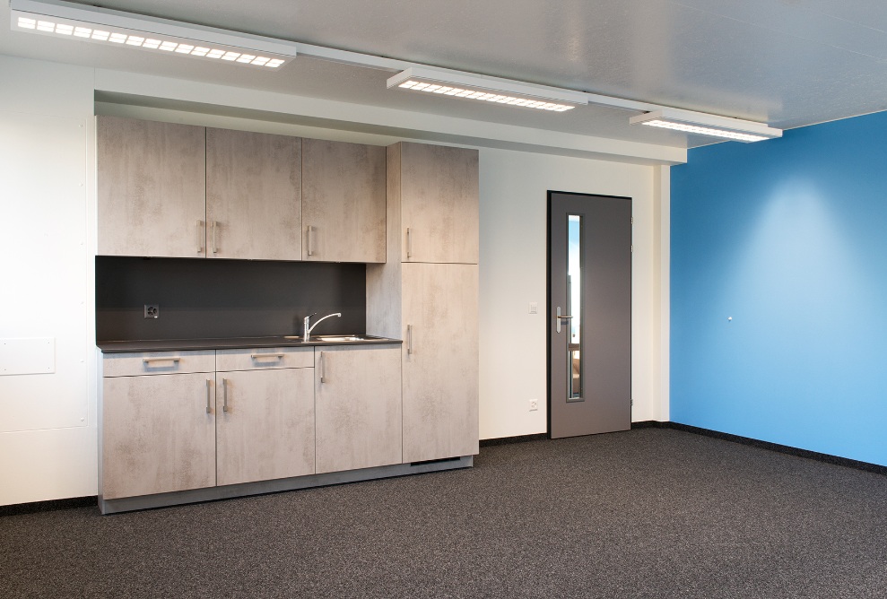 Raum im Büroprovisorium von Lausanne Transport mit Küchenzeile.