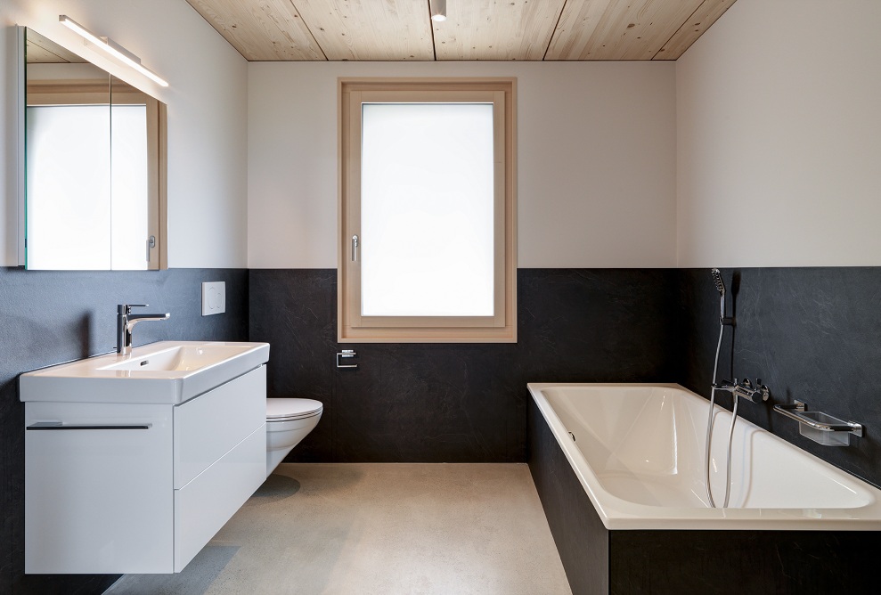Badezimmer in Schwarz und Weiss mit Akzenten in Holz im Mehrfamilienhaus Quellenhof