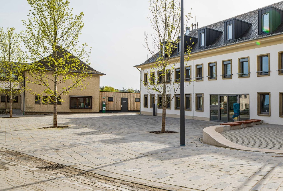 Gesamtansicht Dorfplatz Biwer mit Holzmodulbau 