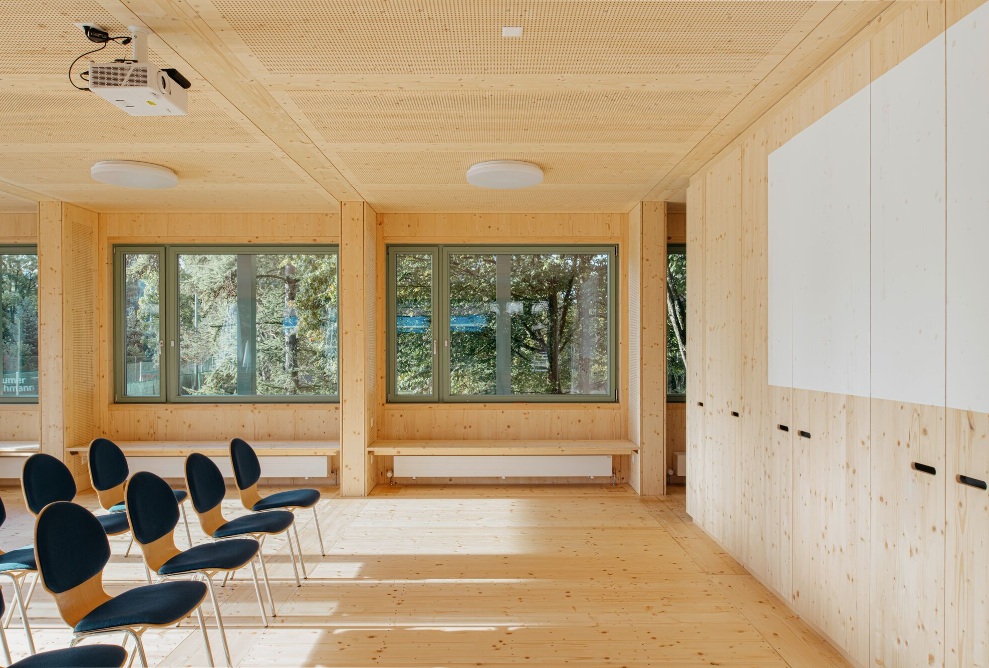 Vue intérieure du pavillon du terrain de sport avec aménagement intérieur en bois.