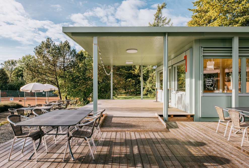 Pavillon vert clair du terrain de sport avec terrasse et sièges