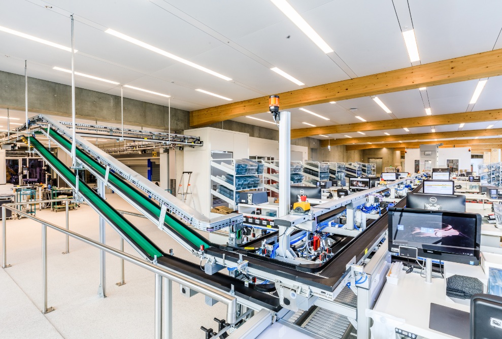 Prise de vue de l’atelier de production Omega lumineux avec structure de toit en bois