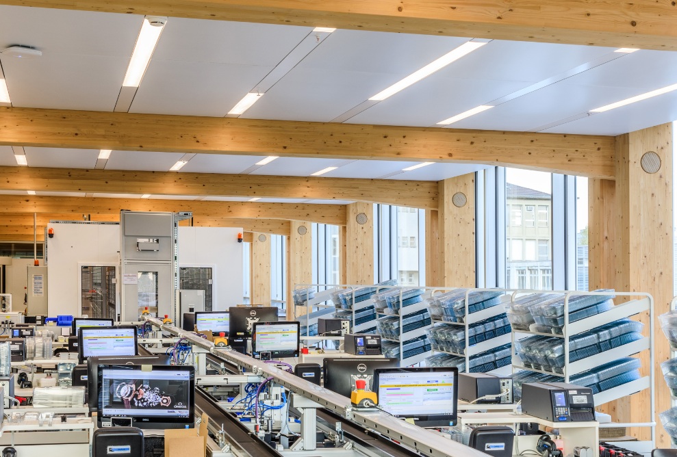 Photograph of the Omega production workshop with timber roof structure and bright, open spaces