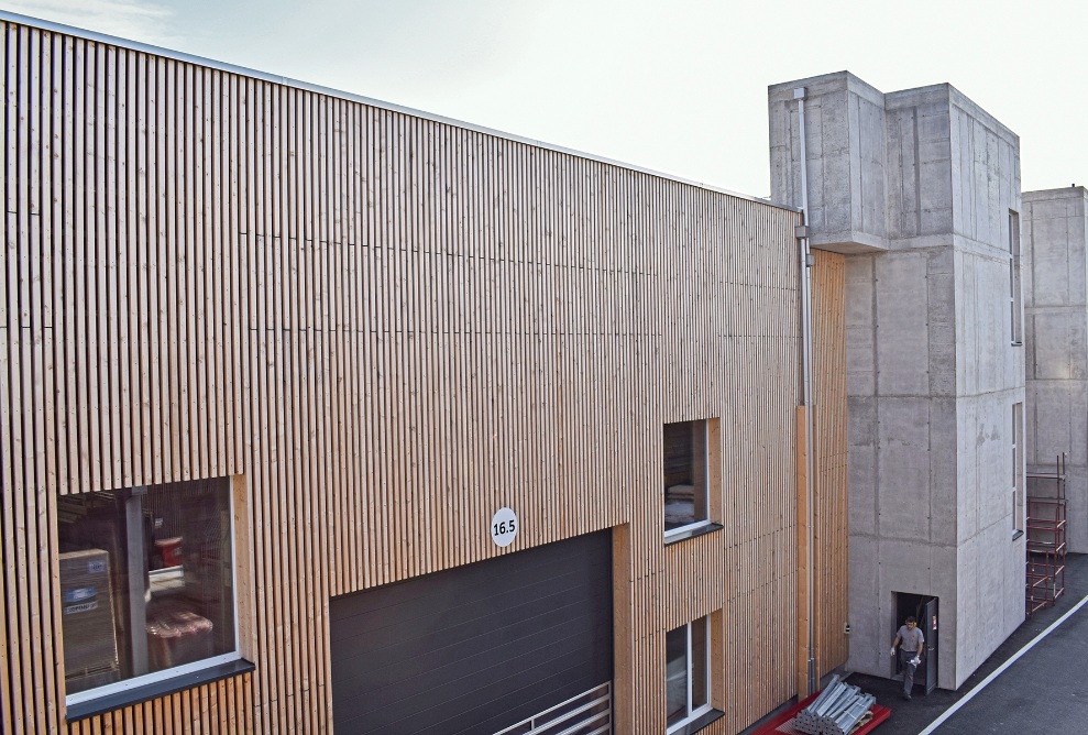 Aussenansicht der Produktionshalle 16 mit ihrer Fassade in Holz und Beton